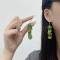 Elegant green acrylic disc tassel drop earrings shown on model for a trendy summer look - Multi-layer Round Acetate Tassel Style (E4857) / Green