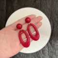 Vibrant red oversized oval resin earrings held in hand for size and style reference - Glossy Red Large Oval Ring Style / Gold (E5251)