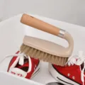 Ergonomic wooden handle cleaning brush for laundry and shoes on red canvas sneakers - Cleaning Brush