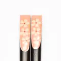 Makro-Detailansicht eleganter Holzstäbchen mit rosa Sakura-Kirschblütenmustern im Detail - Nagel Druck-Rosa Weiß Sakura (25 Lang)