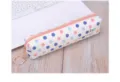 Detail view of white PU pencil case featuring blue and pink polka dots with metal keychain - Pink Polka Dot