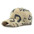 Versleten beige honkbalpet met marineblauwe graffiti-print en diverse gescheurde details - Stijl 3 / Khaki