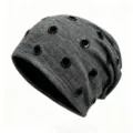 Detail view of grey slouchy beanie hat featuring multiple black metal grommets for a punk hip-hop style - Elastic Fits 56-60cm Head / Heather Gray With Black Rings