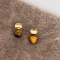 Close-up of elegant retro round stud earrings with amber tiger-eye beads and gold accents - Geometric Patchwork Bead Style (E5021) / Gold Brown