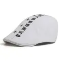 Stylish white cotton beret flat cap featuring black Gothic text and silver star studs - One Size / Letter Style / White