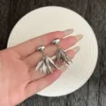 Vue détaillée de boucles d'oreilles à pampilles feuilles argentées sur la main. - Boucles d'Oreilles Clous à Gland en Feuilles Style Froid (E5008) / Argent