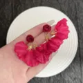Vue macro de boucles d'oreilles vintage en pétales de tissu rouge en main - Boucles d'Oreilles en Tissu Pétales de Rose Rouge Vintage (E5011) / Or