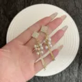 Nahaufnahme eleganter französischer Ohrhänger mit Strass-Quadrat und Perlenquaste - Französische Perlen Schlangenkette Quastenohrringe (E5004) / Gold