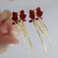 Detail view of elegant deep red velvet bow earrings featuring long gold chain tassels - Velvet Bow Knot Long Tassel Style (E4048 Gold Wine Red)