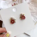 French retro red floral stud earrings with pearl-like detail on white display card. - Red Floral Studs (E2227)