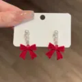 Exquisite red velvet bow earrings with three delicate white pearls shown on white card - Red Bow Three Pearl (E2452)