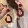 Close-up of elegant French vintage dark red teardrop earrings shown on a model's ear - Hollow Teardrop Style (E5043)