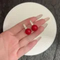 Gros plan de boucles d'oreilles en perles rouges avec strass scintillants, style vintage français - Boucles d'Oreilles Clous Perle Micro-Strass (E5022) / Rouge Doré
