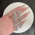 Vue détaillée des boucles d'oreilles à pompons en argent et strass étincelants - Boucles d'Oreilles Longues à Gland Strass Complet Robustes Européennes et Américaines (E5020) / Argent