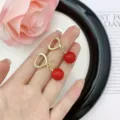 Elegant heart-shaped gold earrings featuring crystals and vibrant Ankora red round beads - Heart Rhinestone Spherical Pendant Style (E2465)