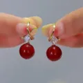 Detailed macro shot of elegant red pearl earrings with sparkling square zircons in gold. - Square Rhinestone Red Bead Style (E2575)