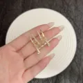 Primo piano di orecchini a goccia dorati con strass scintillanti e pendente raffinato - Stile Nappina Goccia Strass (E4870) / Oro