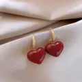 Elegant dark red heart-shaped earrings with gold crystal hooks on silk fabric. - Glossy Rhinestone Heart Pendant Earrings (E4385) / Burgundy