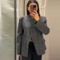 Detailed view of the irregular plaid blazer jacket featuring an asymmetrical collar design. - S / Tops / Grey Plaid