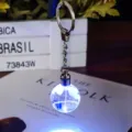 Primer plano de un llavero de globo de cristal brillante con luz LED azul decorativa - Tierra con Luz LED
