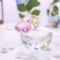 Detailed macro shot of a faceted pink and clear crystal bird nest ornament decoration. - Birds in Nest Figurine