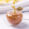 Gros plan détaillé d'une pomme en cristal remplie de gemmes ambrées facettées - Boîte cadeau / Or