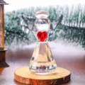 Vista detallada de una figurita de ángel de cristal facetado con un corazón rojo - Ángel de Cristal Transparente con Corazón Rojo