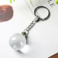 Primer plano de llavero de globo de cristal transparente con continentes grabados y cadena - Globo (K5 Transparente)