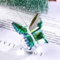 Detailed close-up of a premium green faceted crystal butterfly ornament placed on a book - Butterfly Design / Bright Green