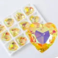 Macro view of iridescent yellow heart-shaped crystal pendant for DIY jewelry making - Heart Style B / 12 Pieces/Pack / Yellow