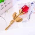 Makroansicht eines Kristallrosen-Ornaments mit goldenem Metallstiel und roter Knospe - Goldener Stab / Kartonverpackung / Rot