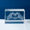 Detalle de cubo de cristal grabado con láser 3D de manos formando un corazón regalo. - Corazón de Cristal Manos