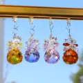Close-up view of four colorful faceted glass crystal ball suncatchers hanging on a rail - 1 Piece / Champagne