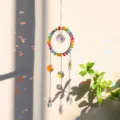 Detail shot of rainbow crystal suncatcher pendant with colorful light refraction effects - Round