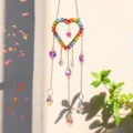 Rainbow crystal heart sun catcher detail with vibrant colorful AB prism drops in sunlight - Heart