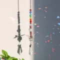 Detailansicht eines Kristall-Sonnenfängers mit Regenbogenperlen, der Reflexionen wirft - Schmetterling-Transparent Tropfen