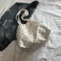 Detalle de un bolso tote informal blanco con lunares sobre una chaqueta vaquera de fondo - Estilo de Lunares / Talla única / Blanco