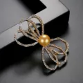 Elegant golden bow brooch featuring a central golden shell pearl and sparkling crystals - Bowknot Golden Pearl Style (X19032703-18K) / Gold