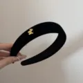 Gros plan détaillé d'un serre-tête élégant en velours noir avec un charm poney doré - 3cm de Large - Style Cheval / Noir