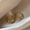 Vista dettagliata di eleganti orecchini a cerchio in oro a U con cristalli ambrati - Stile Cristallo Ambra Forma a U Industria Pesante (E3679) / Oro champagne
