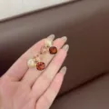 Close-up view of Maillard brown geometric crystal stud earrings held elegantly on a hand. - Geometric Design (E3712) / Golden Coffee