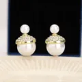 Vista ravvicinata di orecchini di perle in stile francese con brillanti strass - Stile Doppia Perla Francese (E3670) / Oro