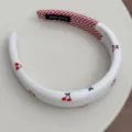 Detailed view of white padded headband featuring cute cherry prints and red checkered lining - Padded Headband Style (FQ86173) / 3cm