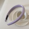 Primer plano de una diadema acolchada color lavanda sobre una taza de té de cerámica - Diadema de Seda Brillante / 2 cm de Ancho / Púrpura