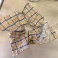 Vue détaillée du motif à carreaux et de la dentelle délicate du chouchou style doux. - Chouchou Foulard Carré / Carreaux bleu et jaune