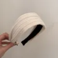 Détail d'un serre-tête en tricot blanc crème avec texture torsadée au style rétro chic - Serre-tête Tricoté / Beige