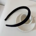 Vue détaillée d'un élégant serre-tête noir à pois avec un label fait main sur porcelaine blanche - Largeur 1.5cm (À Pois) / Noir