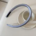 Gros plan d'un serre-tête en satin bleu clair à pois noirs avec étiquette. - Largeur 1.5cm (À Pois) / Bleu