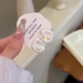 Dettaglio di orecchini a forma di conchiglia irregolare con perle su una scheda di supporto - Stile Perla Ondulazione di Conchiglia (E4999) / Argento