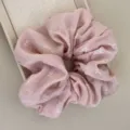 Gros plan d'un chouchou rose poudré avec de jolis motifs de nœuds blancs et pois - Chouchou / Rose